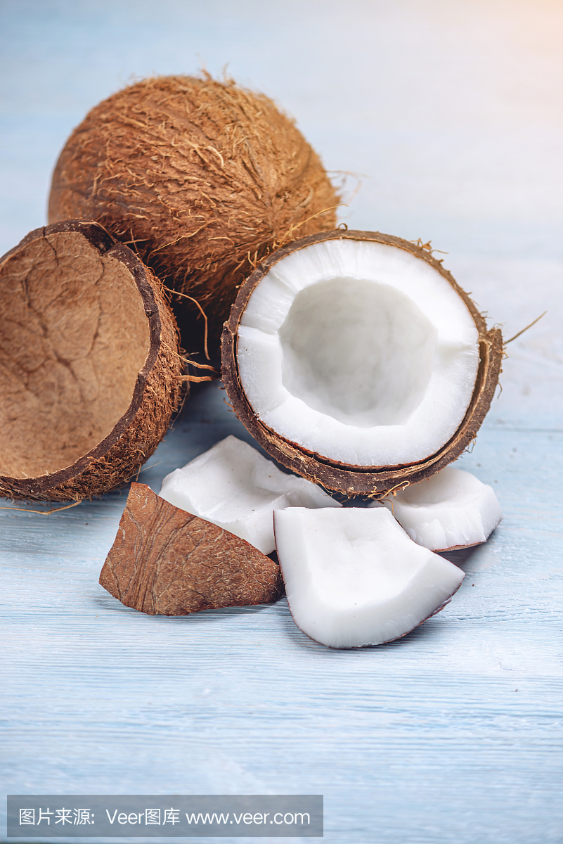 打開椰子與白色果肉在藍(lán)色木制背景。有機(jī)健康膳食產(chǎn)品廣泛應(yīng)用于化妝品